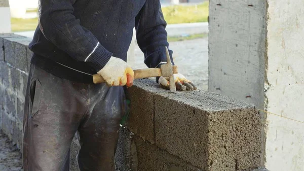 Pekerja konstruksi membangun dinding bata, pandangan dekat di lokasi konstruksi — Stok Foto