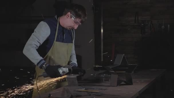 Blacksmith working in a workshop with metal via angle grinder, slow motion. — Stock Video