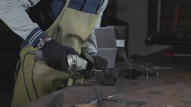 Artigiano utilizzando una smerigliatrice angolare per dettagli in metallo lucido in officina . — Video Stock