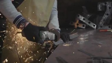 Metal açılı taşlama, ağır çekim üzerinden bir atölyede çalışan demirci.
