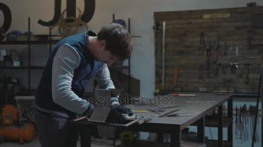 Metal dekoratif detay ile onun atölyesinde çalışan demirci