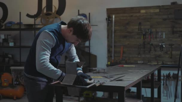 Herrero trabajando con detalle decorativo de metal en su taller — Vídeos de Stock