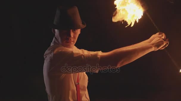 Мужчина выступает с огненным шоу в темноте в замедленной съемке . — стоковое видео