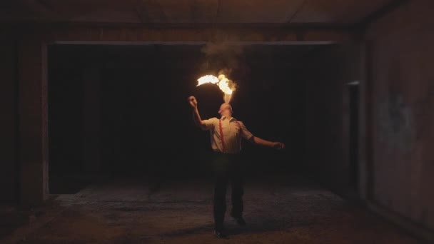 Художник огненного шоу дышит огнем в темноте, замедленной съемке — стоковое видео