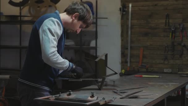 Blacksmith working with metal decorative detail at his workshop — Stock Video