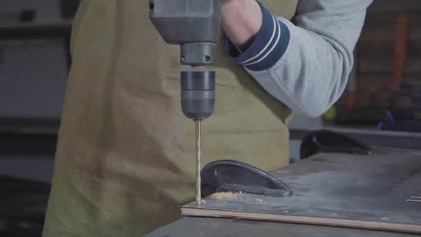 Vista lateral del carpintero perforando un tablón de madera, primer plano cámara lenta . — Vídeos de Stock