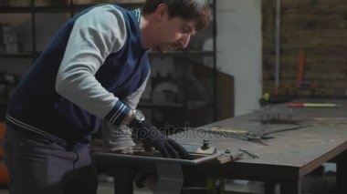 Metal dekoratif detay ile onun atölyesinde çalışan demirci