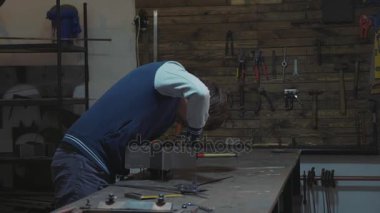 Metal dekoratif detay ile onun atölyesinde çalışan demirci