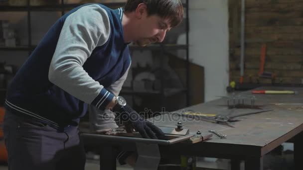 Herrero trabajando con detalle decorativo de metal en su taller — Vídeos de Stock