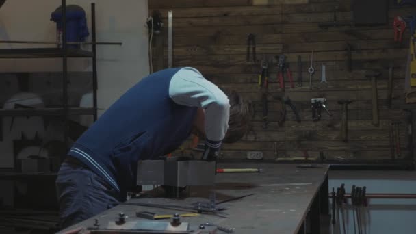 Herrero trabajando con detalle decorativo de metal en su taller — Vídeo de stock