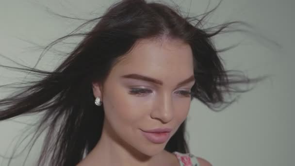 Portrait of beautiful young woman at studio on the gray background. — Stock Video