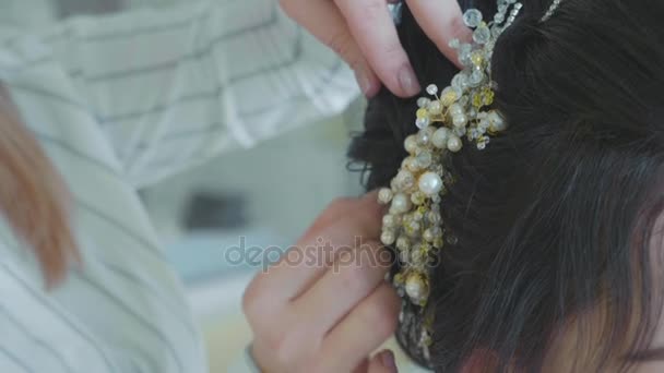 Stylista dokončení účesu pěknou mladou nevěstu na svatební den. — Stock video