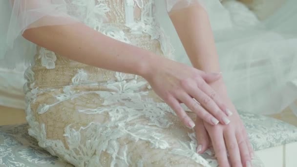 Crop corpo della giovane sposa in abito da sposa si siede mentre truccatore come opere . — Video Stock