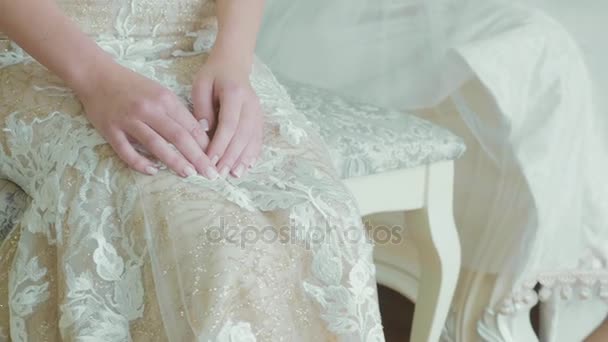 Crop corpo della giovane sposa in abito da sposa si siede mentre truccatore come opere . — Video Stock