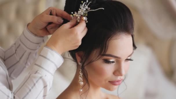 Stylist termina um penteado a noiva jovem bonita no dia do casamento . — Vídeo de Stock