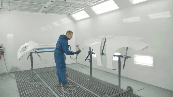 Özel kulübesinde araba yedek çamurluk üzerinde beyaz boya püskürtme otomatik ressam