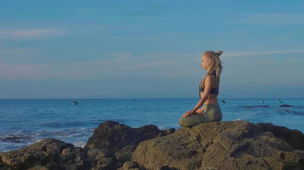 Prática de ioga ao pôr do sol. Yong mulher meditar em lótus posar na praia — Fotografia de Stock