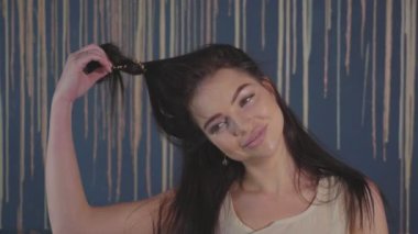 Genç kadın portresi saçını çözer ve şakacı kamera için poz.