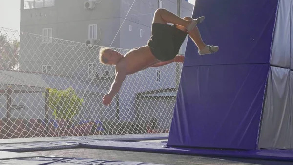 Gimnasta profesional saltando en el trampolín y haciendo trucos en el aire — Foto de Stock