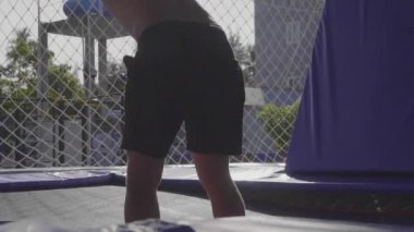 Trambolin üzerinde atlama ve yavaş hareket yapan profesyonel jimnastikçi