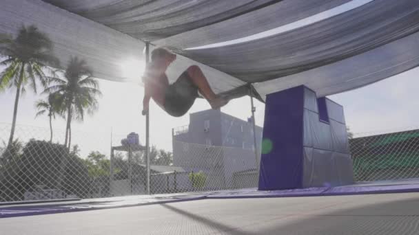 Profi-Turnerin springt auf dem Trampolin und macht Tricks in Zeitlupe — Stockvideo