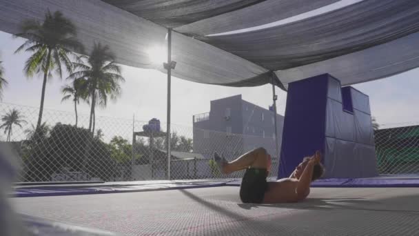 Trambolin üzerinde atlama ve yavaş hareket yapan profesyonel jimnastikçi — Stok video