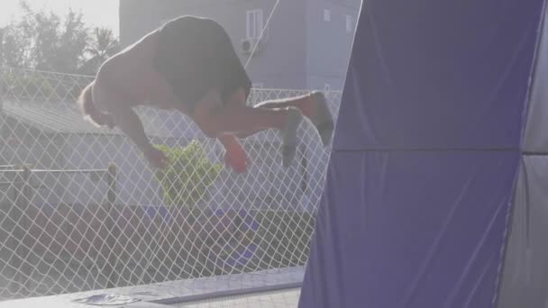 Professionele gymnast springen op de trampoline en doen trucs in slow motion — Stockvideo
