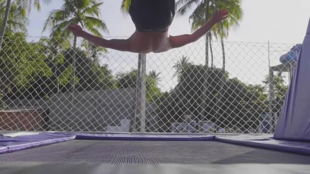 トランポリンでジャンプし、スローモーションでトリックを行うプロの体操選手 — ストック動画