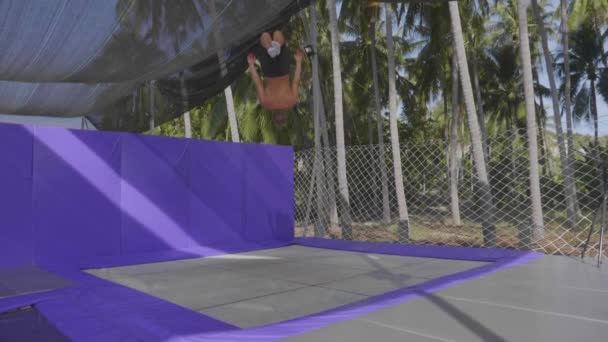 Gimnasta profesional saltando en el trampolín y haciendo trucos en cámara lenta — Vídeo de stock