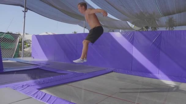 Gimnasta profesional saltando en el trampolín y haciendo trucos en cámara lenta — Vídeos de Stock