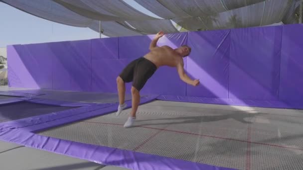 Profesjonalnych gimnastyczka, skoki na trampolinie i robienie sztuczek w zwolnionym tempie — Wideo stockowe