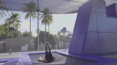 Trambolin üzerinde atlama ve yavaş hareket yapan profesyonel jimnastikçi