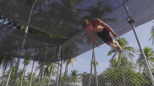 职业体操运动员跳跃在蹦床和做把戏在慢动作 — 图库视频影像