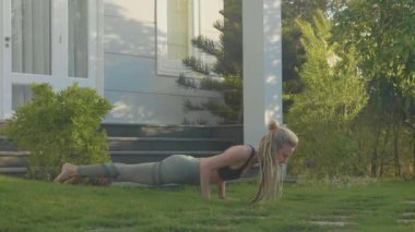 Evinin arka bahçesinde adlı genç bir kız tarafından asana Yoga profesyonel performans