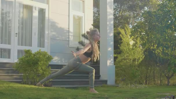 Professionell prestanda av asana yoga av en ung flicka på bakgården av hennes hus — Stockvideo