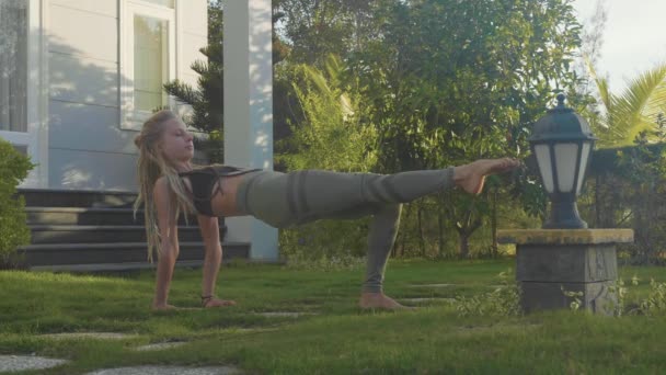 Profesionální výkon ásán jógy mladá dívka na zahradě svého domu — Stock video