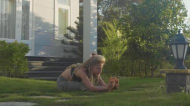 Evinin arka bahçesinde adlı genç bir kız tarafından asana Yoga profesyonel performans