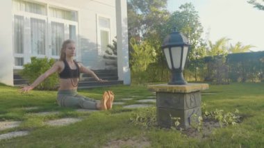 Evinin arka bahçesinde adlı genç bir kız tarafından asana Yoga profesyonel performans