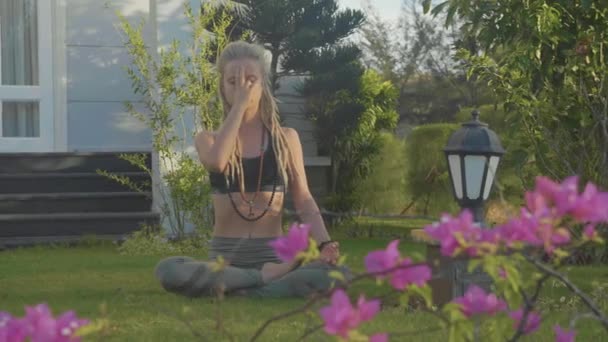 Pranayama yoga adem uitoefenen door een jonge vrouw in de achtertuin van haar huis. — Stockvideo