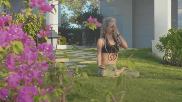 Ejercicio de respiración de yoga Pranayama por una mujer joven en el patio trasero de su casa . — Vídeos de Stock