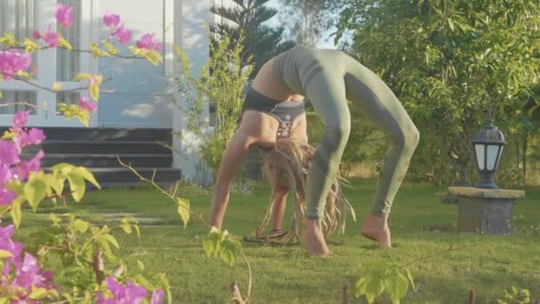 Esecuzione professionale di asana yoga da una giovane ragazza nel cortile della sua casa — Video Stock