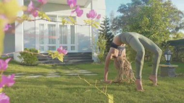 Evinin arka bahçesinde adlı genç bir kız tarafından asana Yoga profesyonel performans