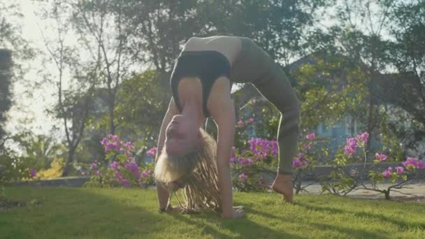 Professionelle Vorstellung von Asana Yoga durch ein junges Mädchen im Hinterhof ihres Hauses — Stockvideo