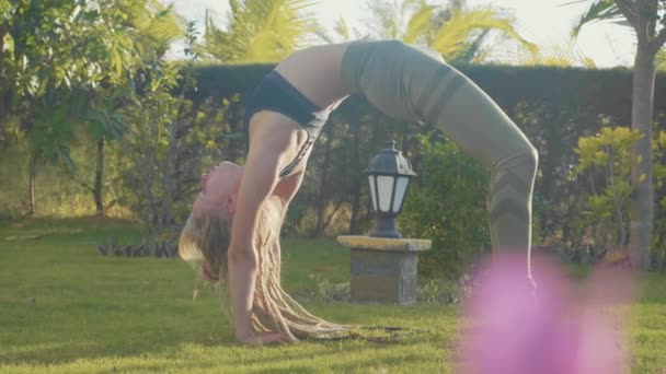 Realización profesional de asana yoga por una joven en el patio trasero de su casa — Vídeos de Stock