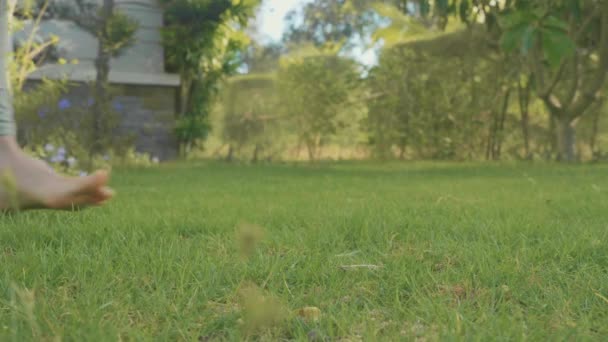 Close-up pés de menina descalça no jardim doméstico com gramado verde em câmera lenta — Vídeo de Stock