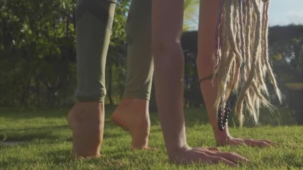 Professionele prestaties van asana yoga door een jong meisje in de achtertuin van haar huis — Stockvideo