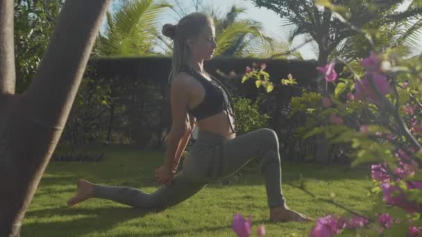 Realización profesional de asana yoga por una joven en el patio trasero de su casa — Vídeo de stock