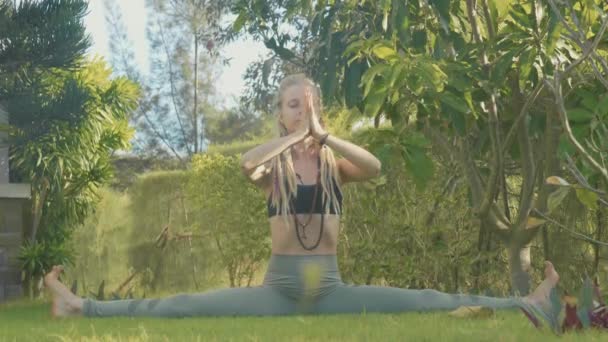 Профессиональное исполнение асаной йоги молодой девушкой на заднем дворе ее дома — стоковое видео