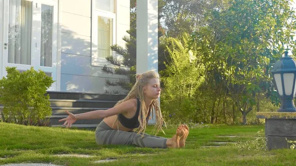 Szakmai teljesítmény asana jóga által egy fiatal lány, a háza kertjében — Stock Fotó