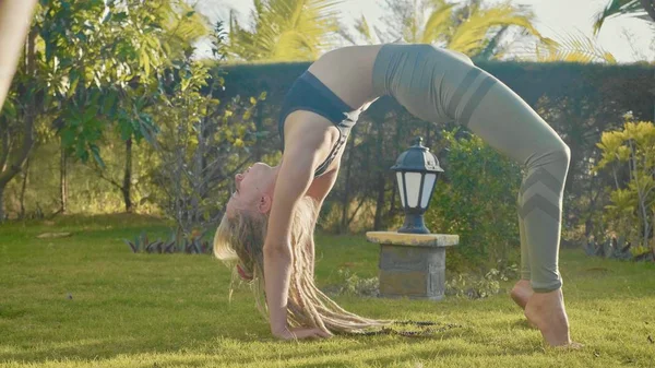 Professionelle Vorstellung von Asana Yoga durch ein junges Mädchen im Hinterhof ihres Hauses — Stockfoto